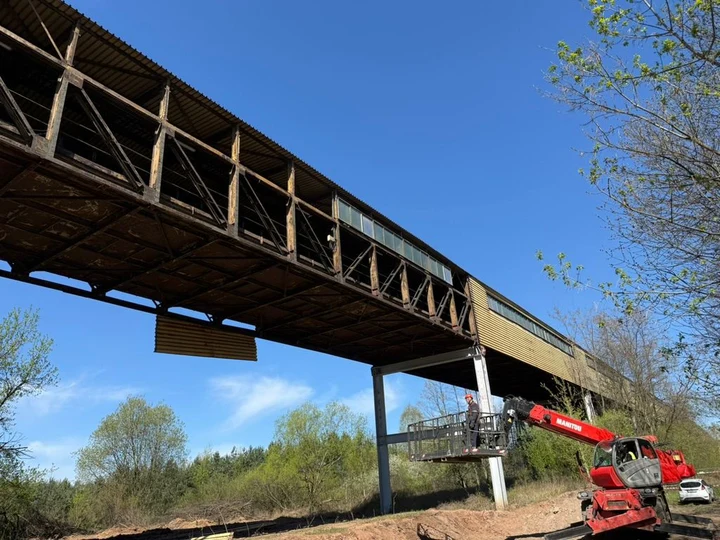 Stalowa konstrukcja transportowa i pracownik w koszu podnośnika